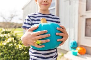 Boy with allergies carrying blue pumpkin