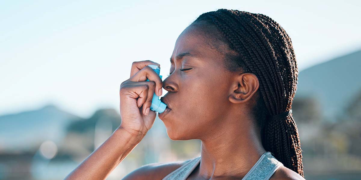 Girl using asthma inhaler on a hot day